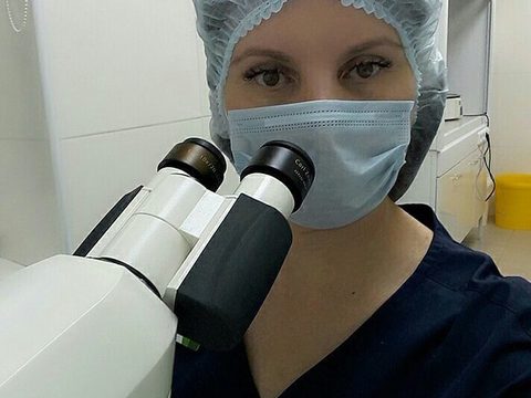 Фотография сотрудника: специалист в маске и шапочке у микроскопа Zeiss Lab.A1
